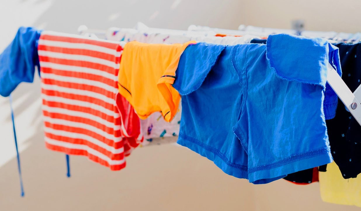 Coloured clothes being dried indoors